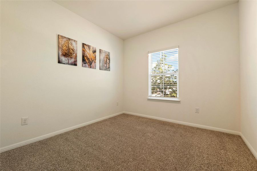 Bedroom #2 features plush carpeting and a large window providing pleasant outdoor views.