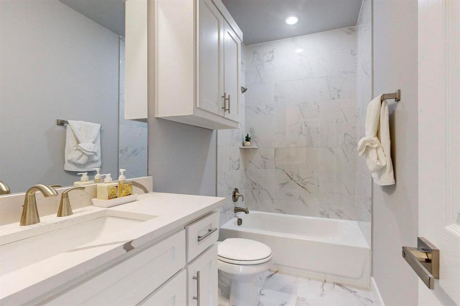 Full bathroom featuring vanity, toilet, and tiled shower / bath combo