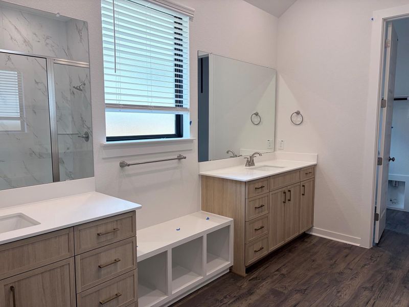 Dual vanities and a spacious shower elevate this modern primary bathroom's appeal. Dual vanities and a spacious shower elevate this modern primary bathroom's appeal.