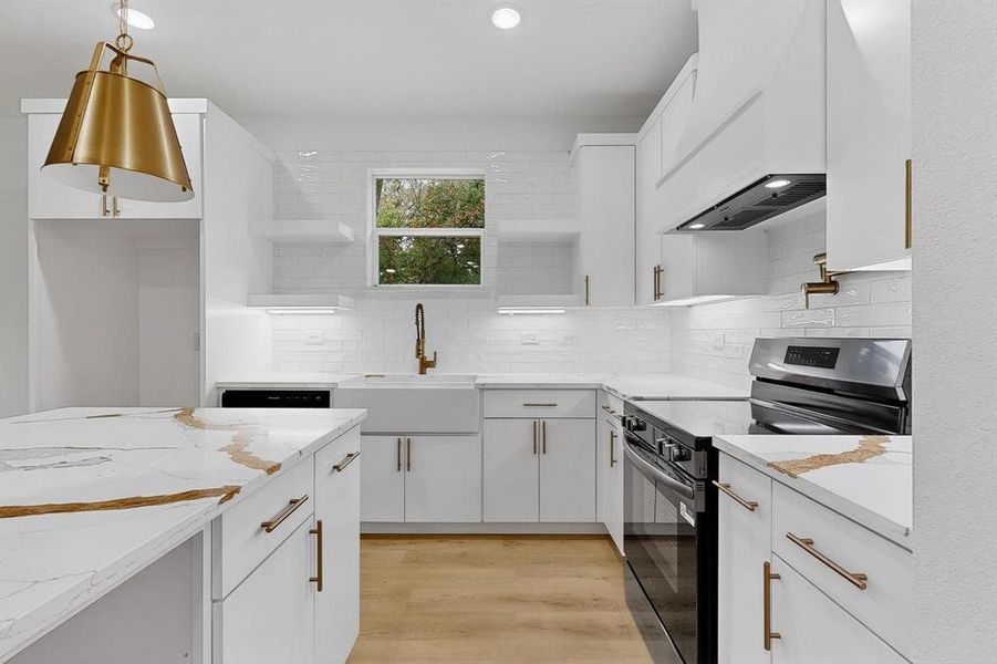 Kitchen with open shelves, black range with electric cooktop, tasteful backsplash, white cabinets, and light wood-style flooring Kitchen with open shelves, black range with electric cooktop, tasteful backsplash, white cabinets, and light wood-style flooring