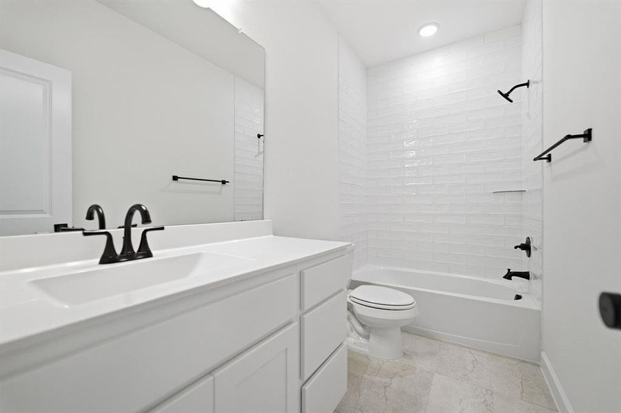 Contemporary bathroom featuring a white vanity with integrated sink, matte black faucet, and a large wall mirror