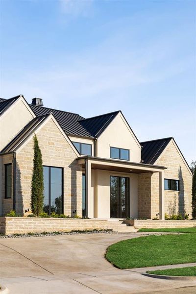 View of front of home featuring a standing seam roof, stone siding, and a metal roof View of front of home featuring a standing seam roof, stone siding, and a metal roof
