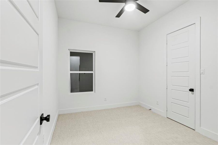 Carpeted spare room featuring ceiling fan