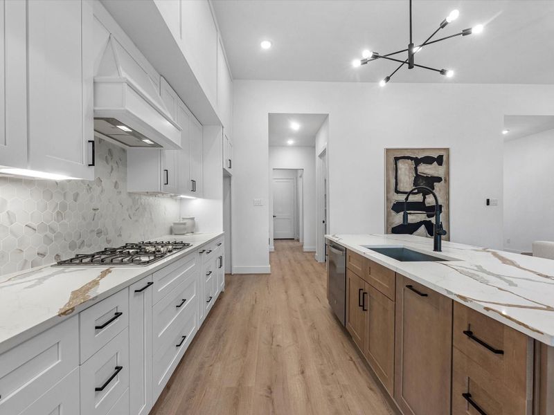 Modern, but warm interior color palette with a white oak island and white cabinets lining the walls, topped with an elegant quartz surface. Modern, but warm interior color palette with a white oak island and white cabinets lining the walls, topped with an elegant quartz surface.