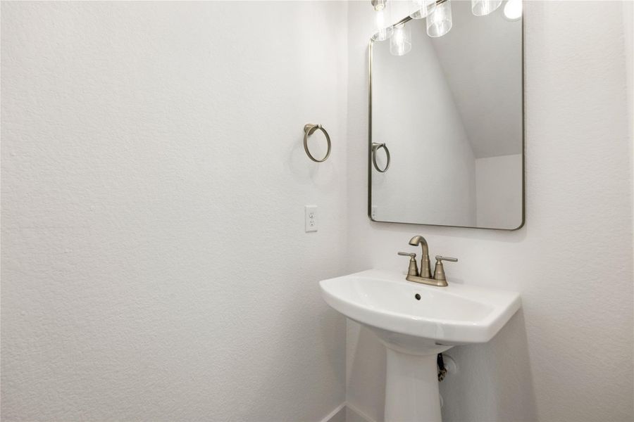 The powder room on the first floor includes a pedestal sink, mirror, sleek and modern fixtures--all to conveniently meet your needs.