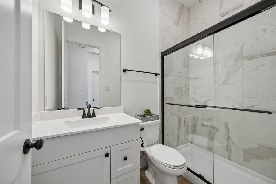 Secondary bath finished with a fully tiled tub and shower surround, paired with a clean glass enclosure and matte black fixtures. Crisp vanity with quartz countertop and modern lighting keeps the space bright and polished. Secondary bath finished with a fully tiled tub and shower surround, paired with a clean glass enclosure and matte black fixtures. Crisp vanity with quartz countertop and modern lighting keeps the space bright and polished.
