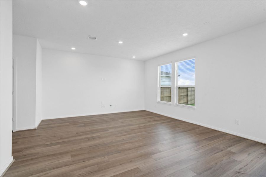 Bring family and friends together in this beautiful family room! It features high ceilings, recessed lighting, custom paint, stunning vinyl plank flooring, and large windows with fitted blinds! Bring family and friends together in this beautiful family room! It features high ceilings, recessed lighting, custom paint, stunning vinyl plank flooring, and large windows with fitted blinds!