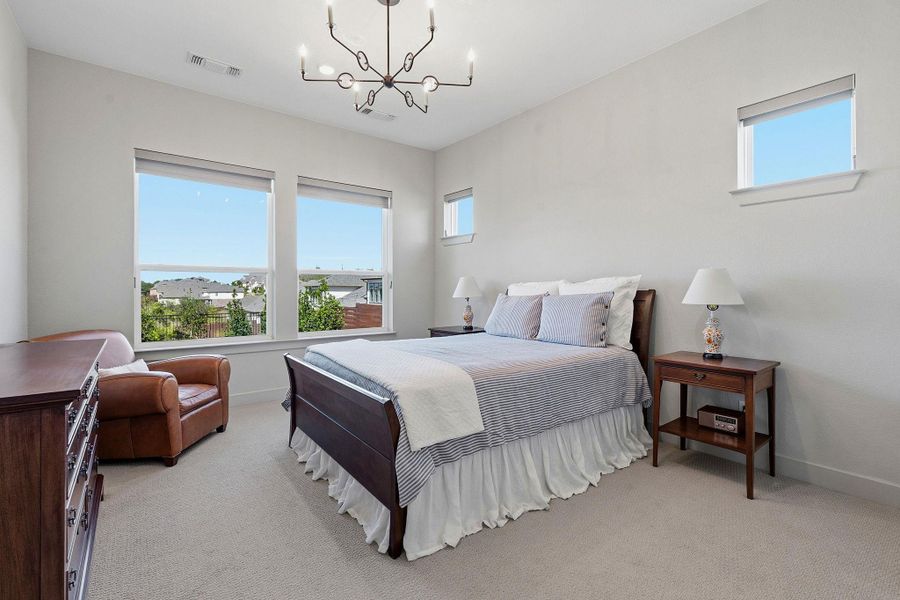 Bedroom with hanging lights and light colored carpet Bedroom with hanging lights and light colored carpet