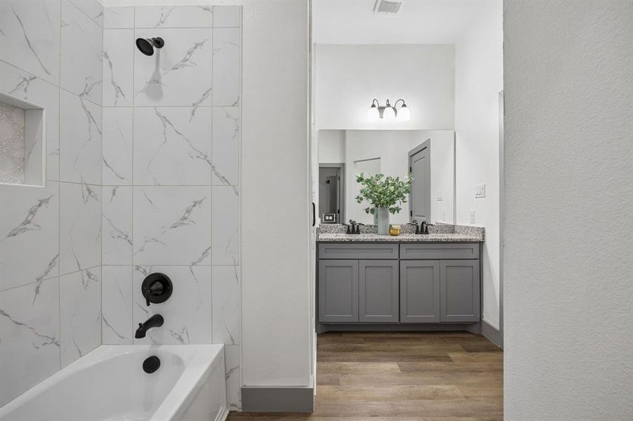Another view of the bonus tub/shower and a view of the vanity with two sinks.