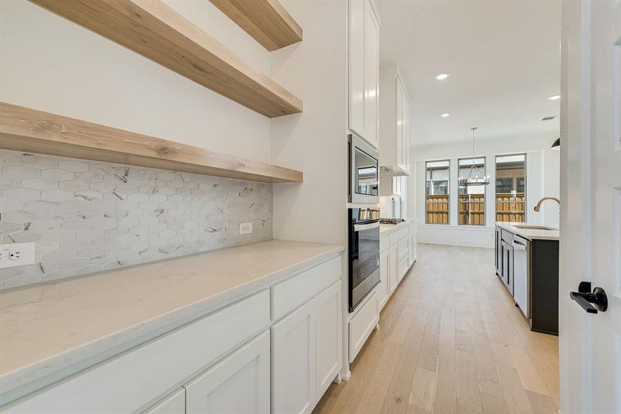 Kitchen featuring white cabinetry, open shelves, recessed lighting, light wood finished floors, and backsplash
