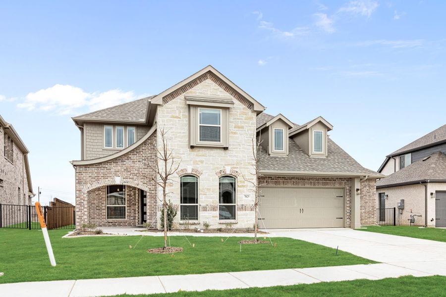 Two-story home with brick and stone exterior, two-car garage, and green front lawn Two-story home with brick and stone exterior, two-car garage, and green front lawn