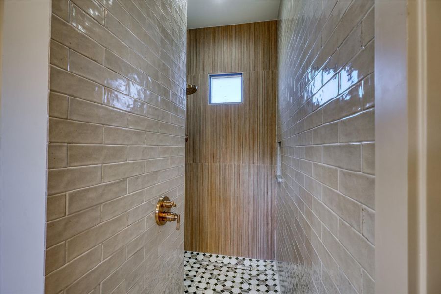 Spa-inspired bath with dual vanities, soaking tub, large walk-in shower, makeup station & custom fixtures.