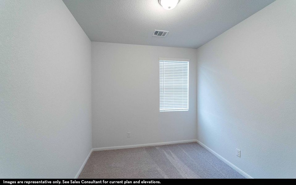 Unfurnished room featuring light colored carpet, a textured ceiling, and a textured wall