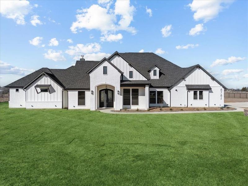 Modern inspired farmhouse featuring a front yard and french doors