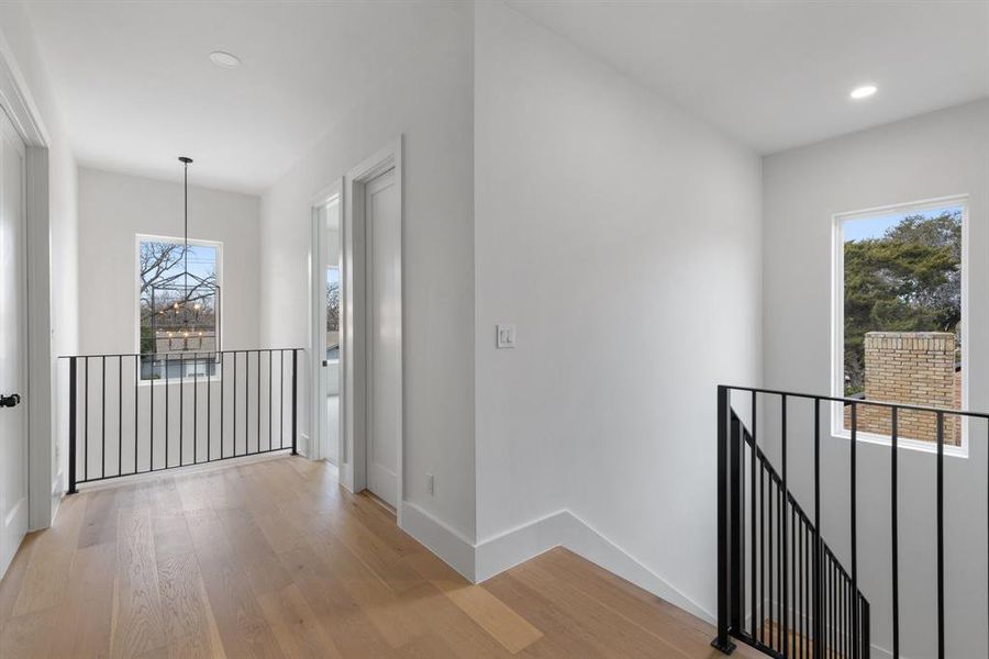 Hallway featuring an inviting chandelier and Upstairs, you’ll find a versatile media room plus a large bonus or game room for endless entertainment possibilities.