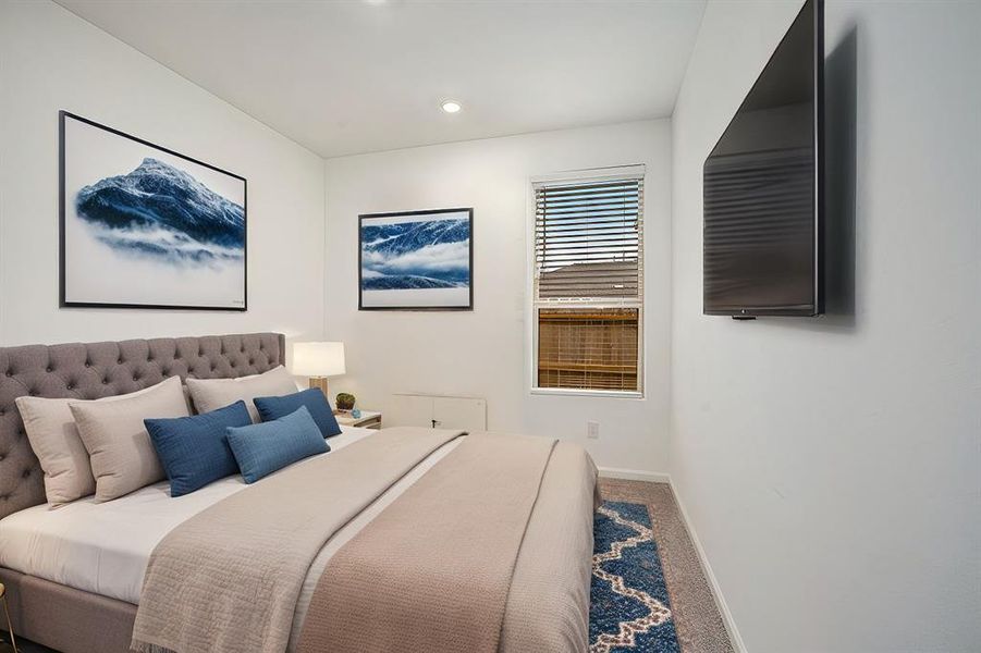 This is a bright, cozy bedroom features a spacious closet.  The room has soft carpeting and a window that allows natural light to fill the space.