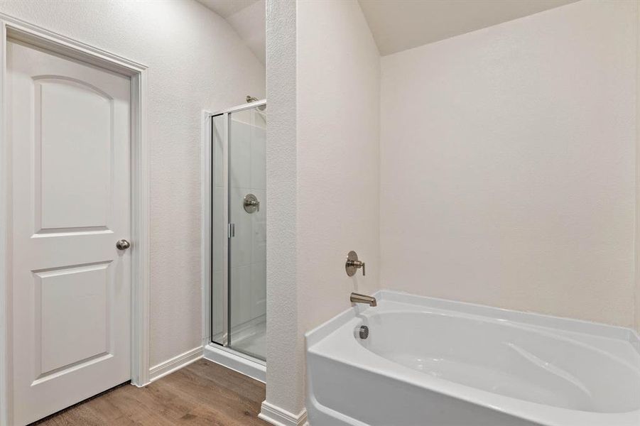 Bathroom featuring wood-type flooring and separate shower and tub