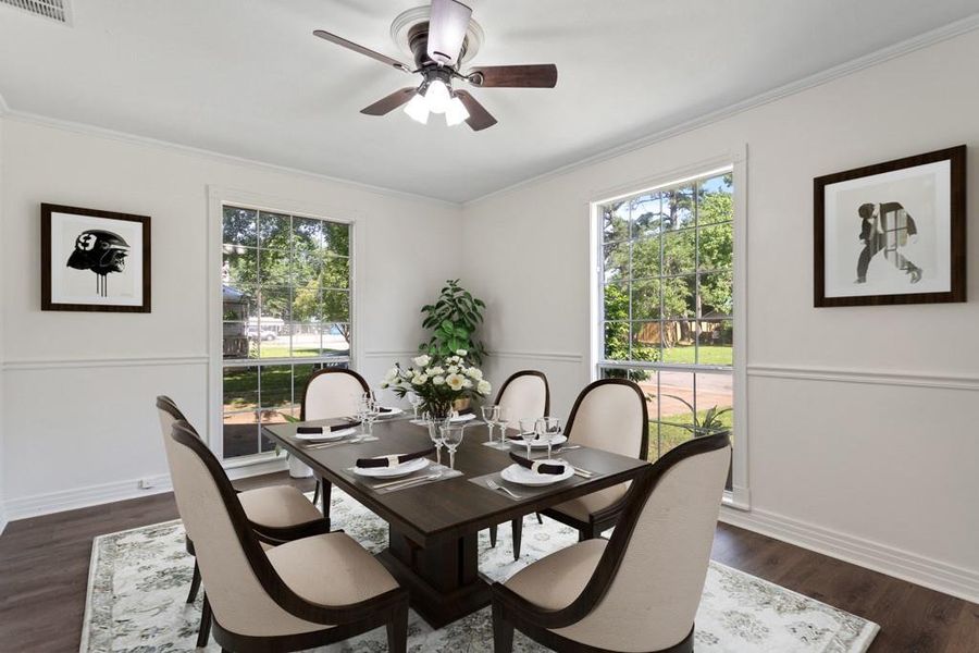 Dining space with a ceiling fan, ornamental molding, dark wood-style flooring, and baseboards