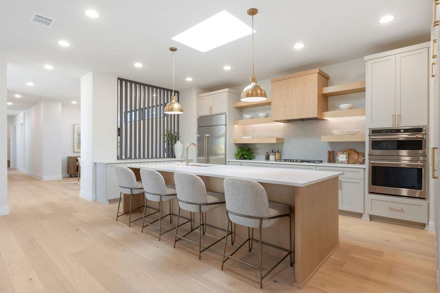 Kitchen featuring visible vents, light countertops, appliances with stainless steel finishes, a skylight, and open shelves