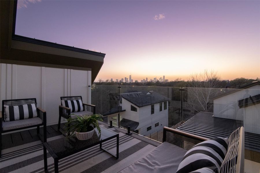 Balcony at dusk featuring a view of city