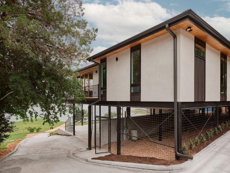 Modern elevated structure with a stucco exterior and dark trim