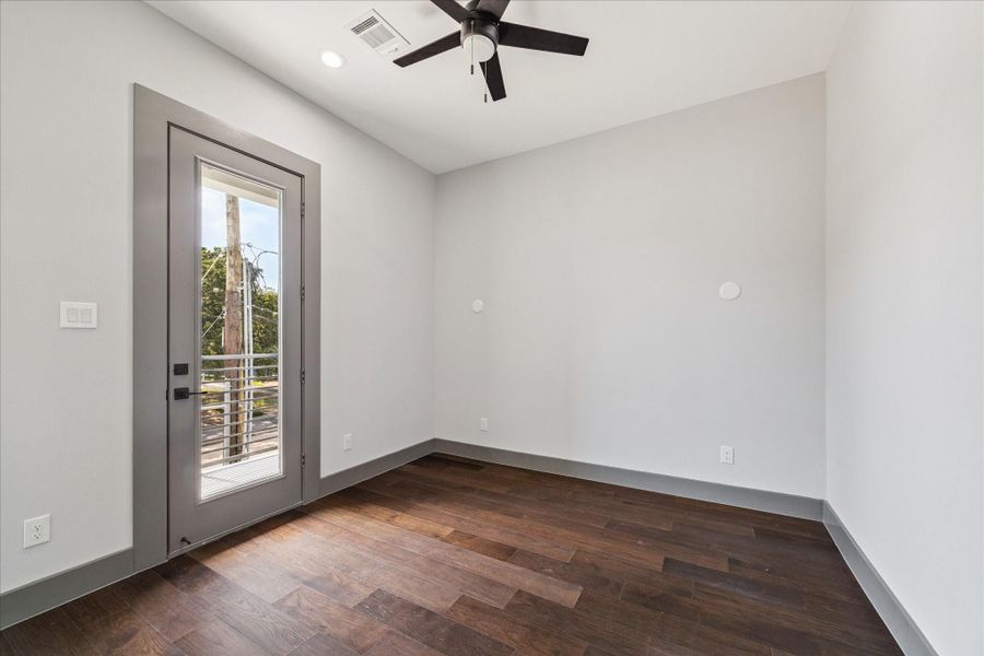 Versatile and bright, the secondary bedroom features wood flooring, neutral walls, and a glass door leading to a private balcony. Versatile and bright, the secondary bedroom features wood flooring, neutral walls, and a glass door leading to a private balcony.