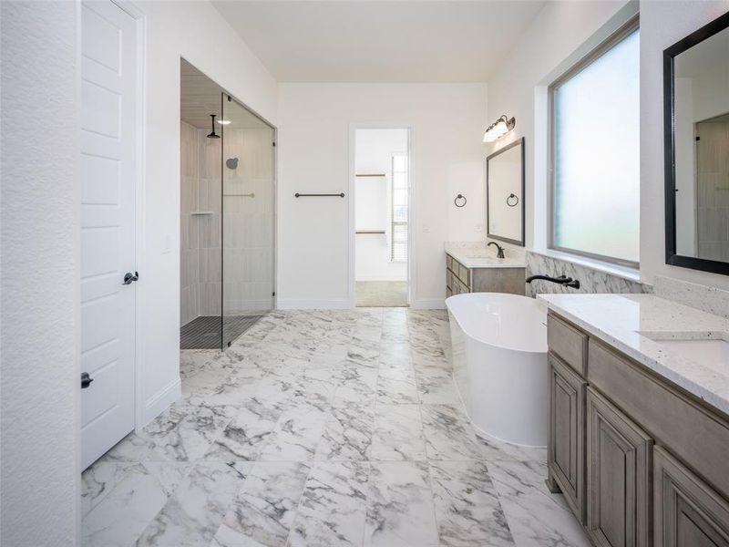 Full bath featuring walk in shower, marble look tile flooring, a freestanding bath, and two vanities Full bath featuring walk in shower, marble look tile flooring, a freestanding bath, and two vanities