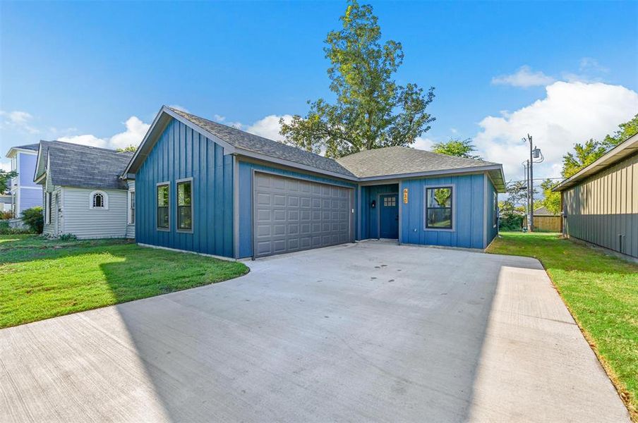 View of front facade featuring a garage and a front yard