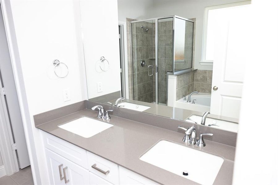 Bathroom featuring a stall shower, double vanity, a bath, and tile patterned flooring Bathroom featuring a stall shower, double vanity, a bath, and tile patterned flooring