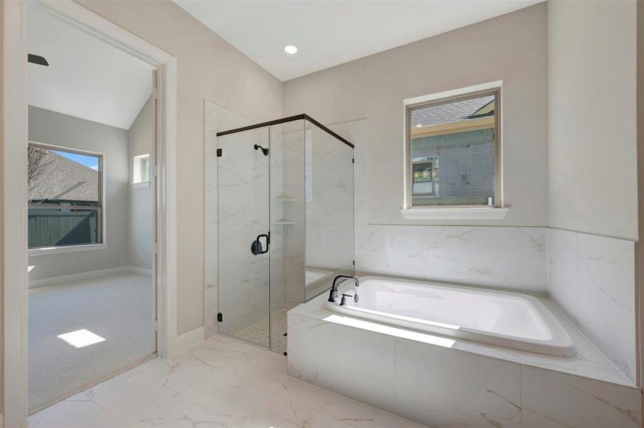 Full bathroom with a marble finish shower, light marble finish flooring, a bath, and light colored carpet Full bathroom with a marble finish shower, light marble finish flooring, a bath, and light colored carpet