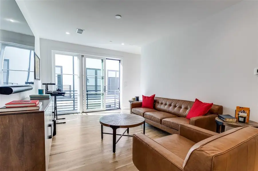 Living room featuring light wood-type flooring and recessed lighting Living room featuring light wood-type flooring and recessed lighting