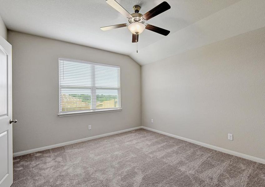 Spacious master bedroom with windows and a ceiling fan.