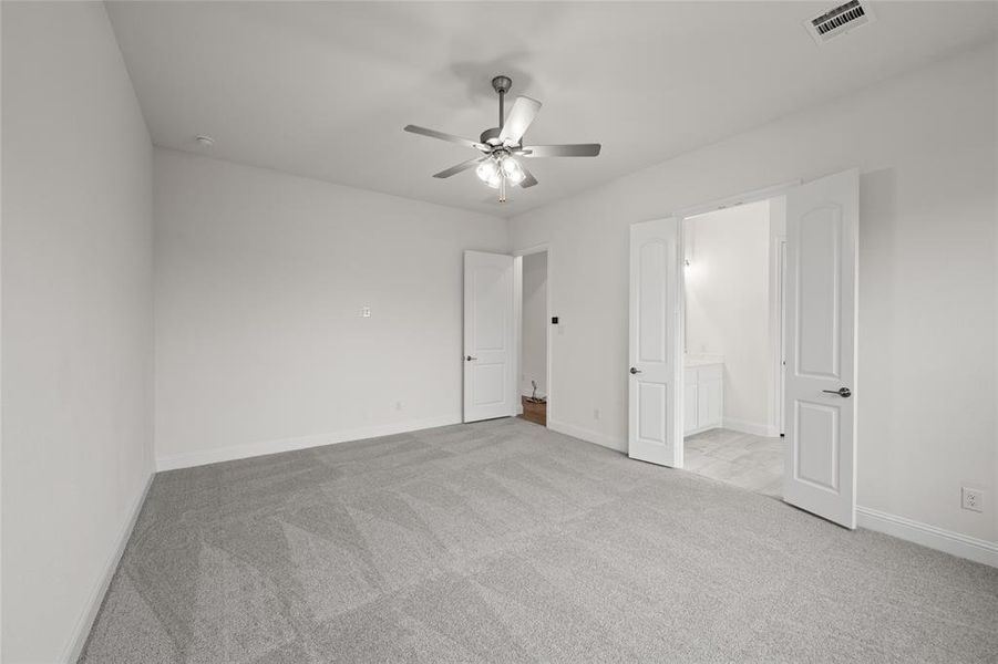 Unfurnished bedroom featuring carpet, baseboards, ensuite bathroom, and a ceiling fan Unfurnished bedroom featuring carpet, baseboards, ensuite bathroom, and a ceiling fan