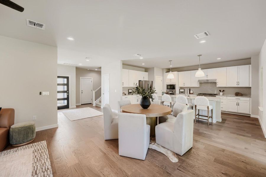 Elegant hardwood flooring unites a contemporary open-plan kitchen and a welcoming dining area, ideal for social gatherings. Elegant hardwood flooring unites a contemporary open-plan kitchen and a welcoming dining area, ideal for social gatherings.