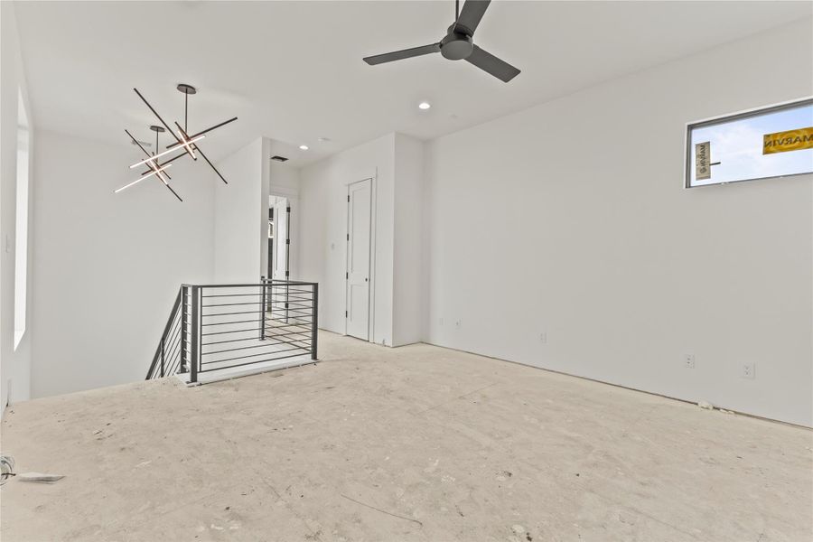Upper-level landing featuring a contemporary linear chandelier and modern ceiling fan