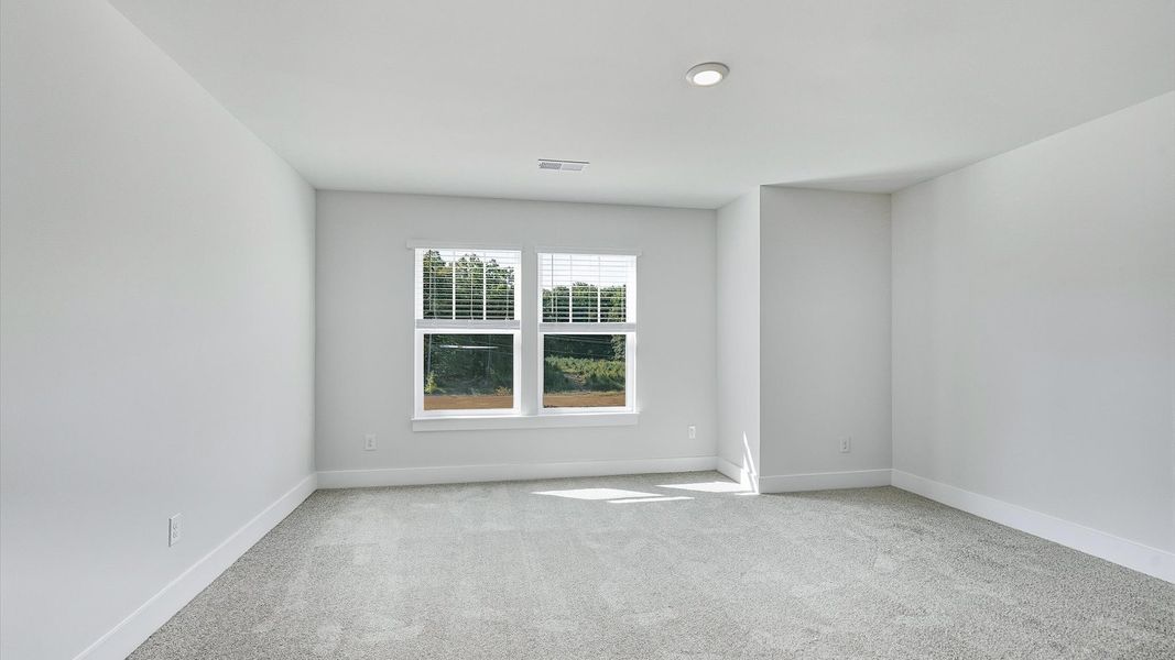 Refined bedroom design with large windows for daylight-filled mornings and peaceful views in Fountain Inn, SC