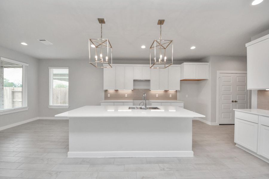 This kitchen is by far any chef’s dream! This spacious kitchen features high ceilings, light stained wood cabinets, granite countertop, SS appliances, modern tile backsplash, recessed lighting, extended counter space, granite kitchen island with double sink, and space for breakfast bar, and a walk-in pantry all overlooking your huge family room. Sample photo of completed home with similar floor plan. Actual colors and selections may vary.