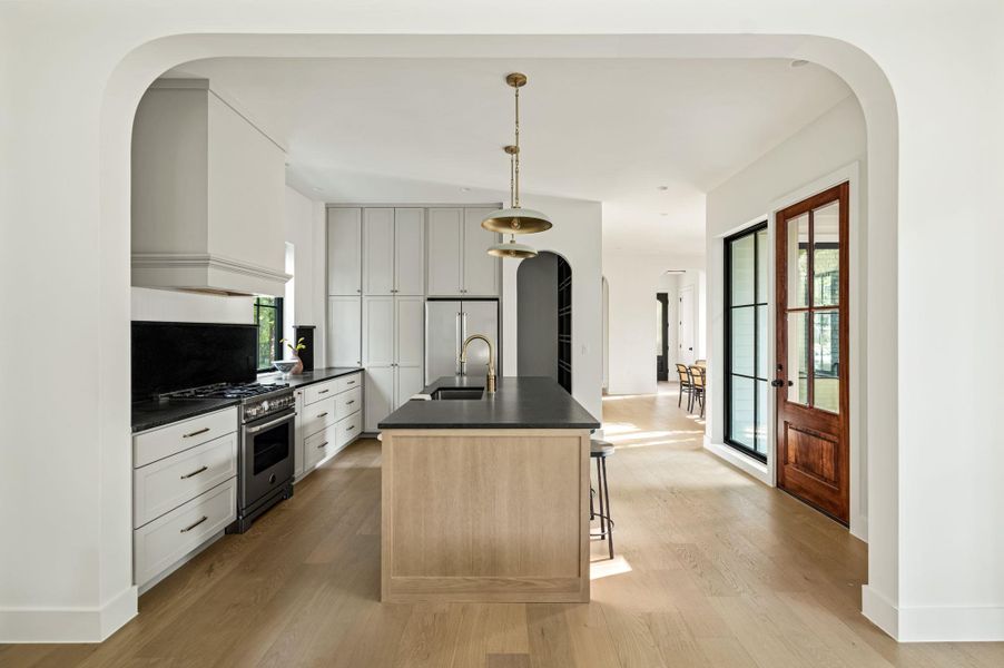 Culinary delights await in this light-filled kitchen, featuring a central island and sleek stainless appliances.
