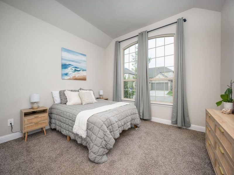 This cozy secondary bedroom features plush carpeting, soft, soothing paint tones, and ample natural light!