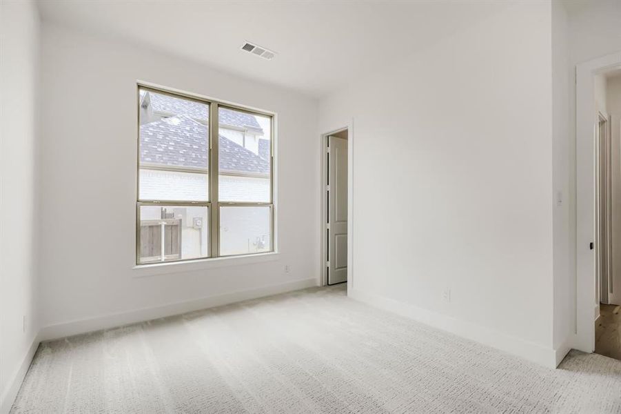 Spare room with light colored carpet and baseboards