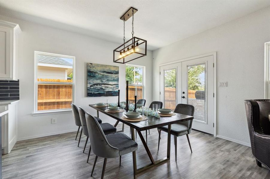 Dining space with a notable chandelier, light hardwood / wood-style flooring, and french doors