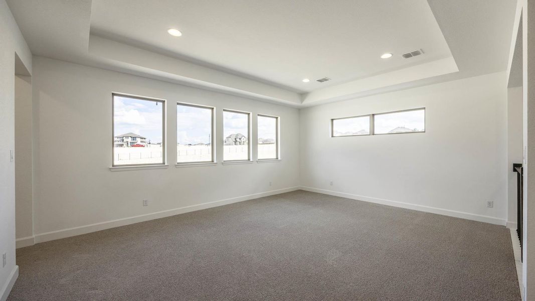 Empty room featuring a tray ceiling, light carpet, and recessed lighting Empty room featuring a tray ceiling, light carpet, and recessed lighting