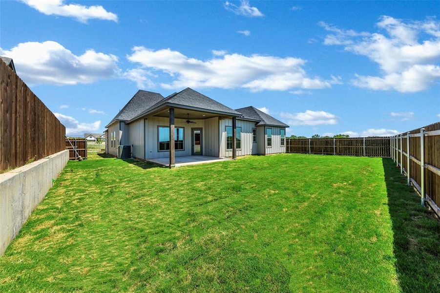 Back of house featuring ceiling fan, a shingled roof, a patio, and a fenced backyard