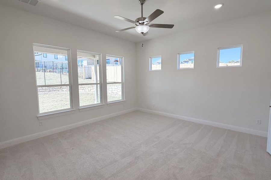 Spare room featuring light carpet and a ceiling fan