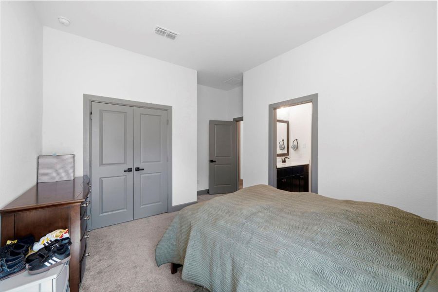 Well-appointed secondary bedroom featuring soft carpeting, neutral finishes, and convenient access to a nearby bath—offering both comfort and functionality for everyday living.