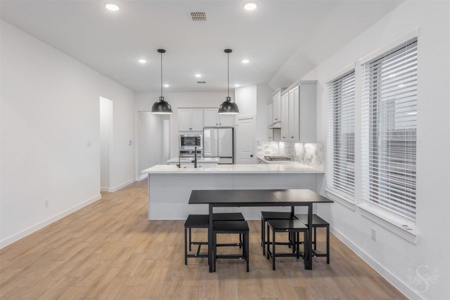 The bright breakfast area sits beside oversized windows, offering easy access to the beautifully designed kitchen with beautiful counters, upgraded cabinetry, and stainless appliances. Its open connection to the main living areas enhances the home's spacious, airy feel. The bright breakfast area sits beside oversized windows, offering easy access to the beautifully designed kitchen with beautiful counters, upgraded cabinetry, and stainless appliances. Its open connection to the main living areas enhances the home's spacious, airy feel.