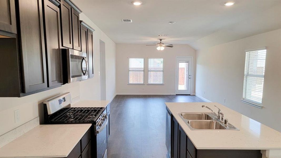 Kitchen featuring appliances with stainless steel finishes, an island with sink, open floor plan, dark wood-style floors, and recessed lighting Kitchen featuring appliances with stainless steel finishes, an island with sink, open floor plan, dark wood-style floors, and recessed lighting