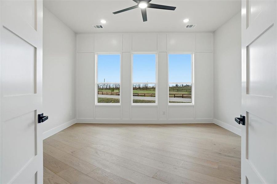 Spacious bonus room with decorative wall trim and large windows, ideal for a game room, media room, or additional living space.