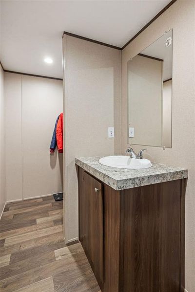 Contemporary vanity with a granite-style countertop, integrated sink, and dark wood-finish cabinetry Contemporary vanity with a granite-style countertop, integrated sink, and dark wood-finish cabinetry
