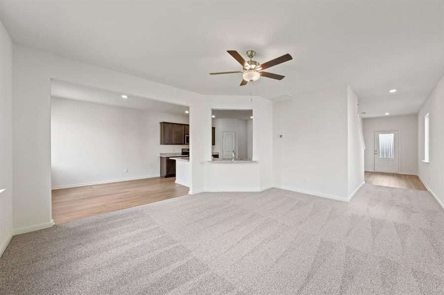 Unfurnished living room with light colored carpet, recessed lighting, and ceiling fan